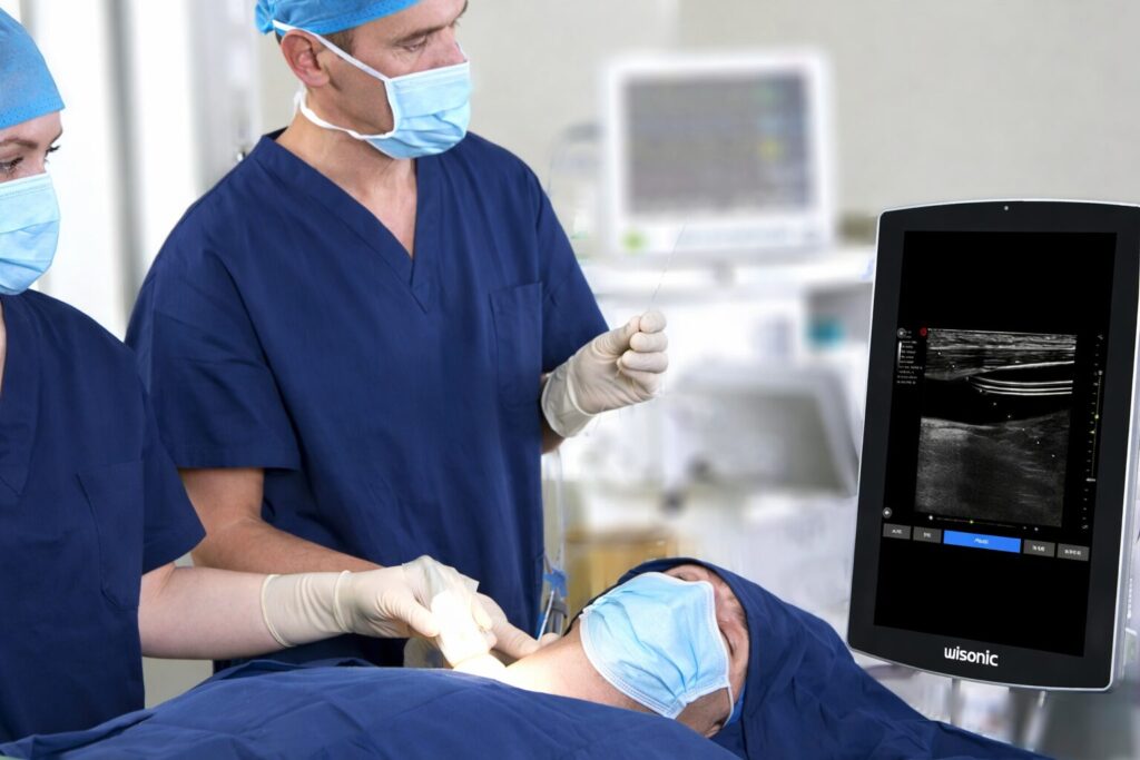 A medical professional using the Navi ultrasound system on a patient during a procedure in a clinical environment, with the ultrasound display showing tissue imaging.